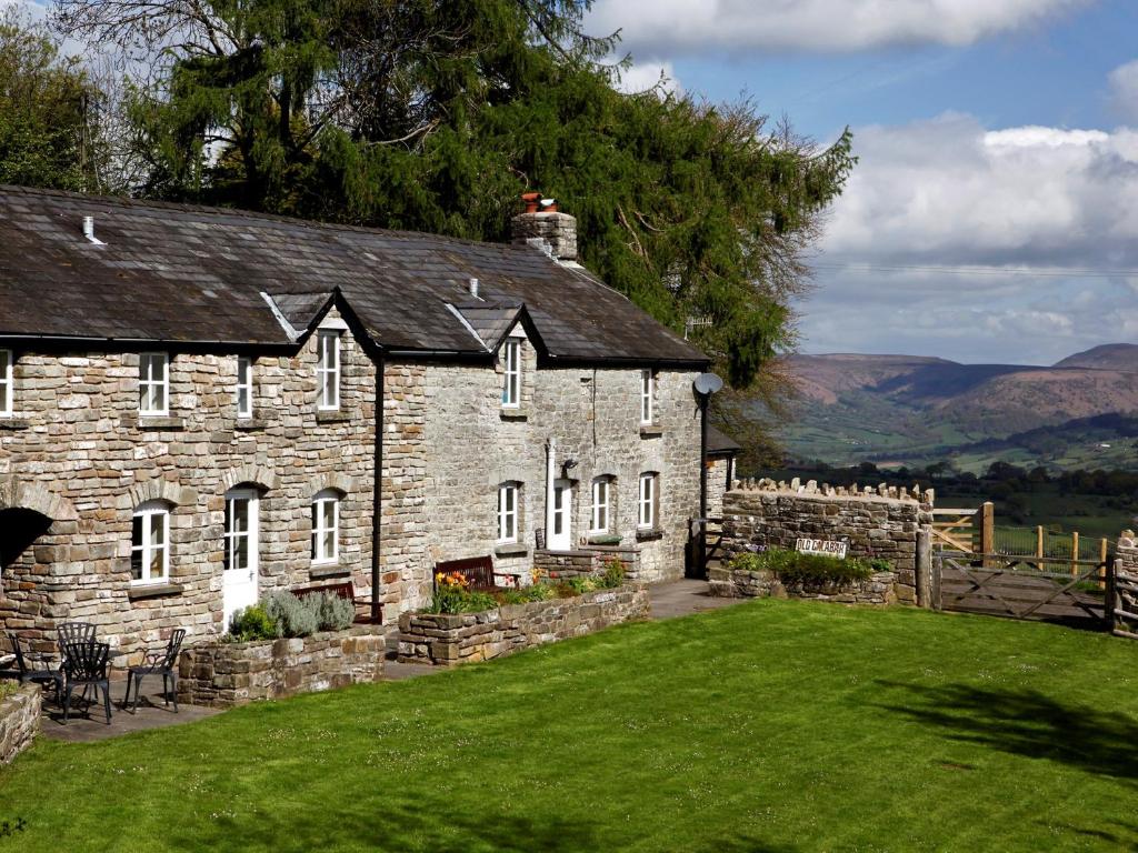 an old stone house with a green lawn at 5 Bed in Crickhowell BN365 in Llangattock