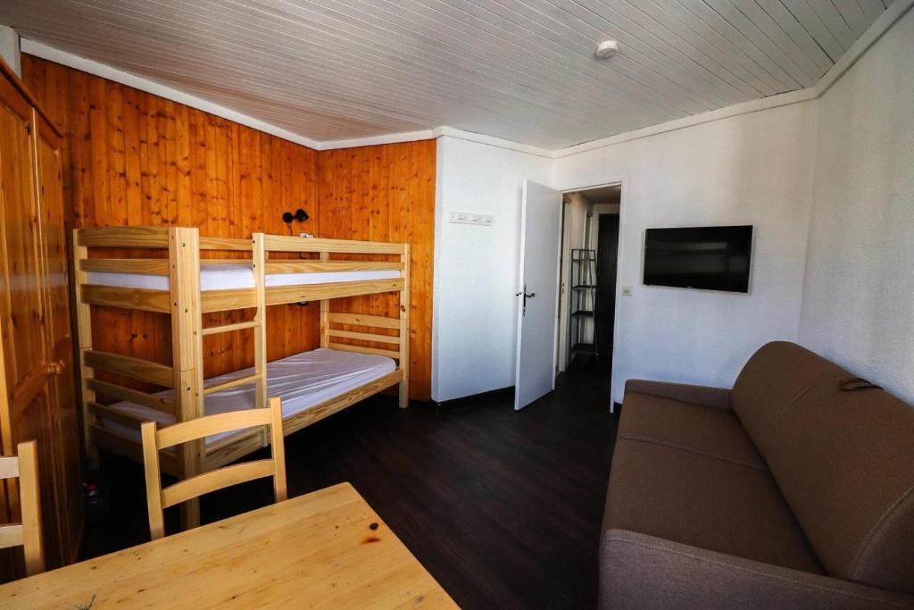 a living room with two bunk beds and a couch at Résidence Sefcotel - Studio pour 4 Personnes 574 in Tignes