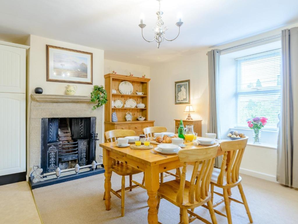 a dining room with a table and chairs and a fireplace at 2 Bed in Rothbury 74811 in Rothbury