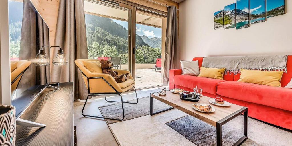 un salon avec un canapé rouge et une table dans l'établissement Résidence Les Terrasses De La Vanoise - CASA COLORADO - PREMIUM 4 - Appartement de 4 pièces 8 personnes en rez de chaussée - 72 m2 MAE-1504, à Champagny-en-Vanoise