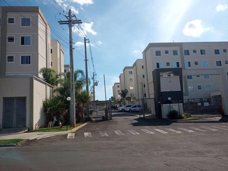 a parking lot with a gate and some buildings at Apartamento locação diária - residencial Belize in Botucatu