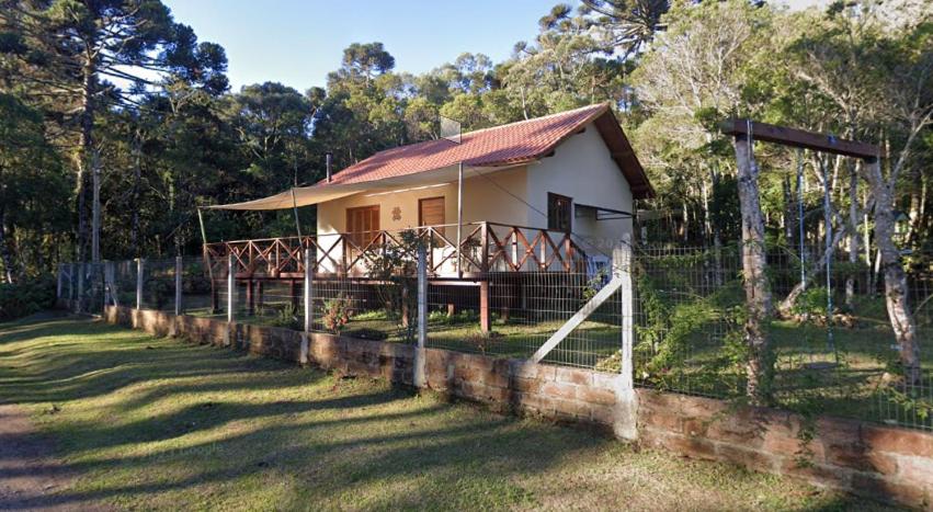 ein kleines weißes Haus mit einem Zaun drum herum in der Unterkunft Morada da Serra Alta in São Francisco de Paula
