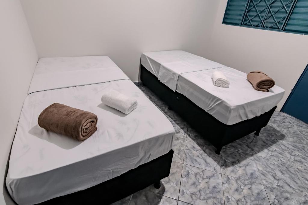 two beds sitting next to each other in a room at Quarto 03 Pousada Roosevelt in Uberlândia