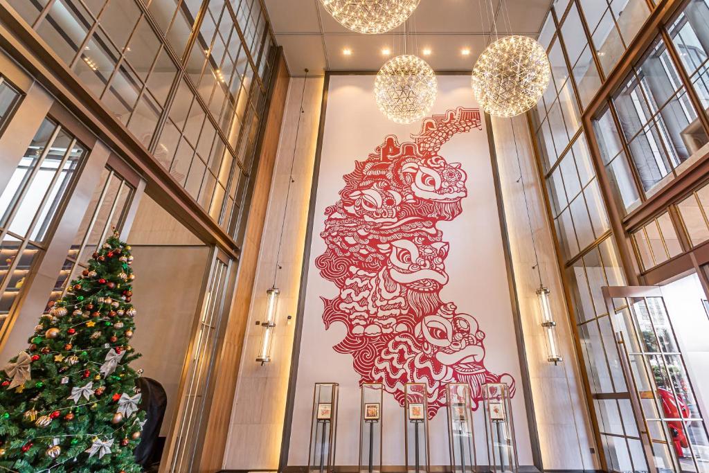 Un albero di Natale in un grande muro in un edificio di UrCove by Hyatt Foshan Downtown a Foshan