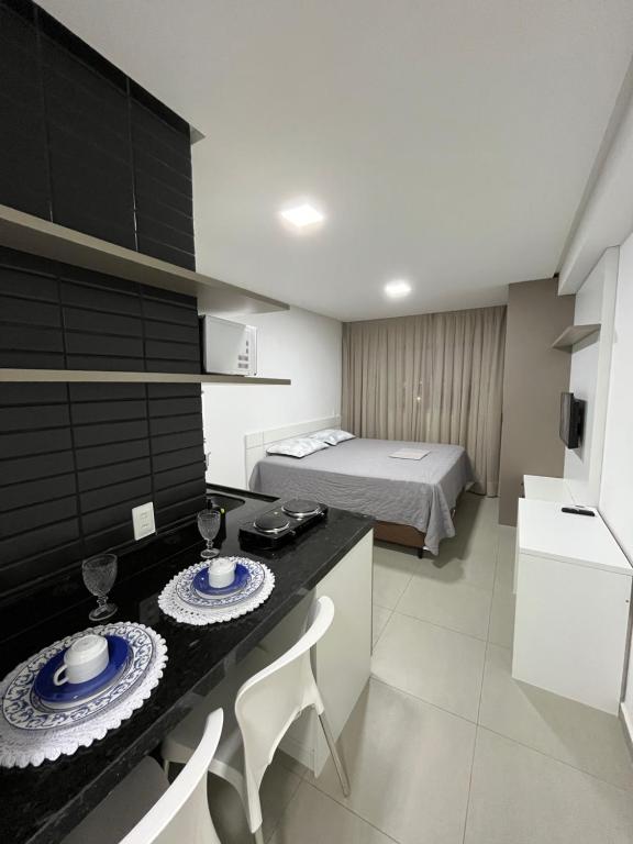 a room with a bed and a table with plates on it at Studio cama King Size Westfit. in Mossoró
