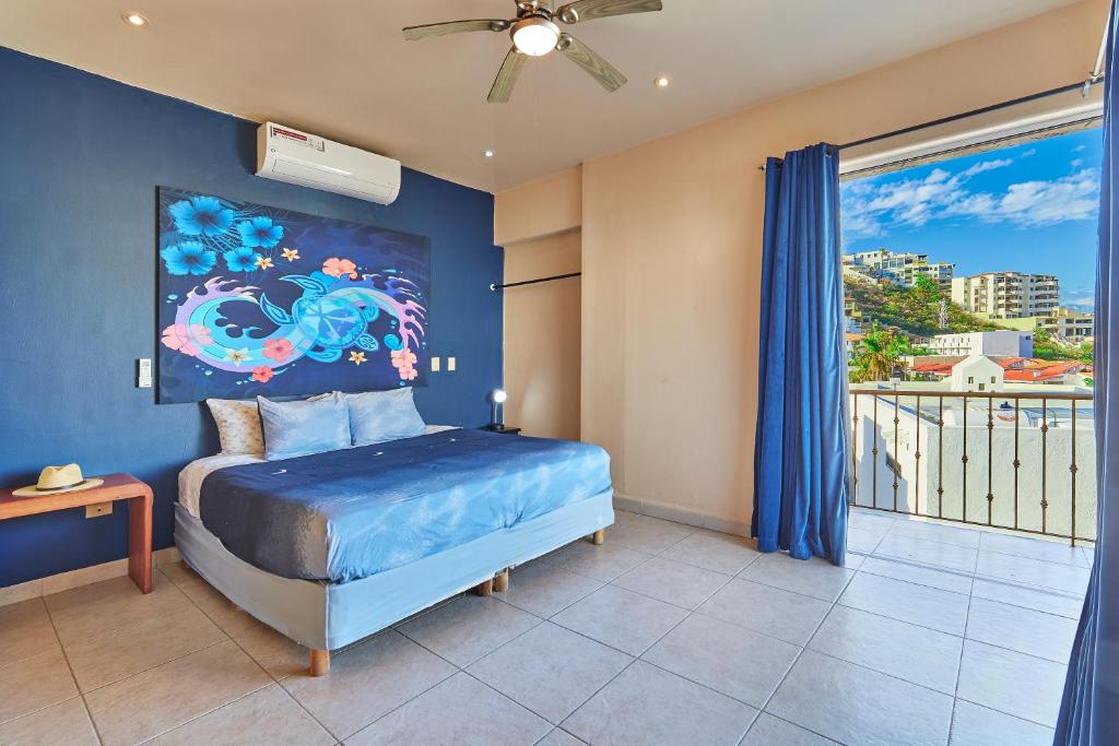 1 dormitorio con 1 cama con una pintura en la pared en Casa Robyn, en Cabo San Lucas