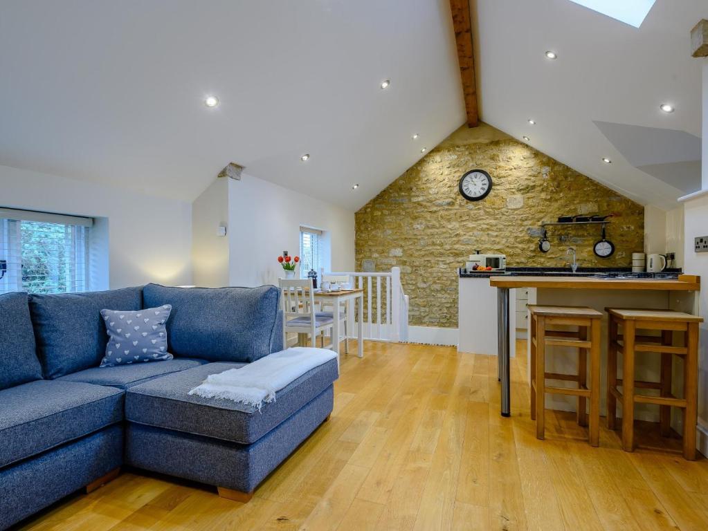 a living room with a blue couch and a kitchen at 1 Bed in Castle Cary 91185 in Castle Cary