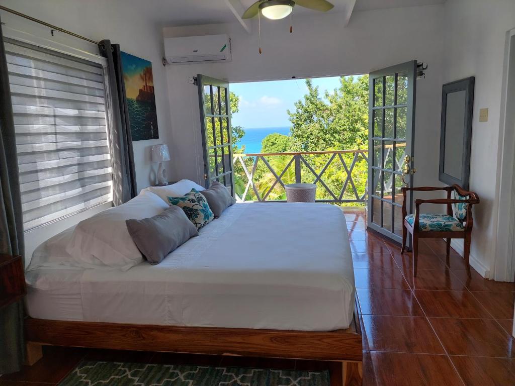 a large bed in a room with a large window at Alex's Place - Tim Pappies in Port Antonio