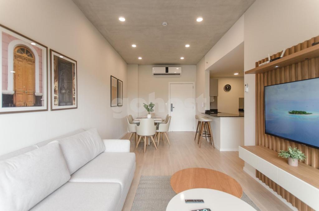 uma sala de estar com um sofá branco e uma televisão de ecrã plano em Modern 2 Bedroom Apartment Near Paseo La Galeria em Assunção