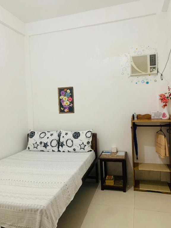 a small room with a bed and a table at Queen's Room Rental 2 in El Nido