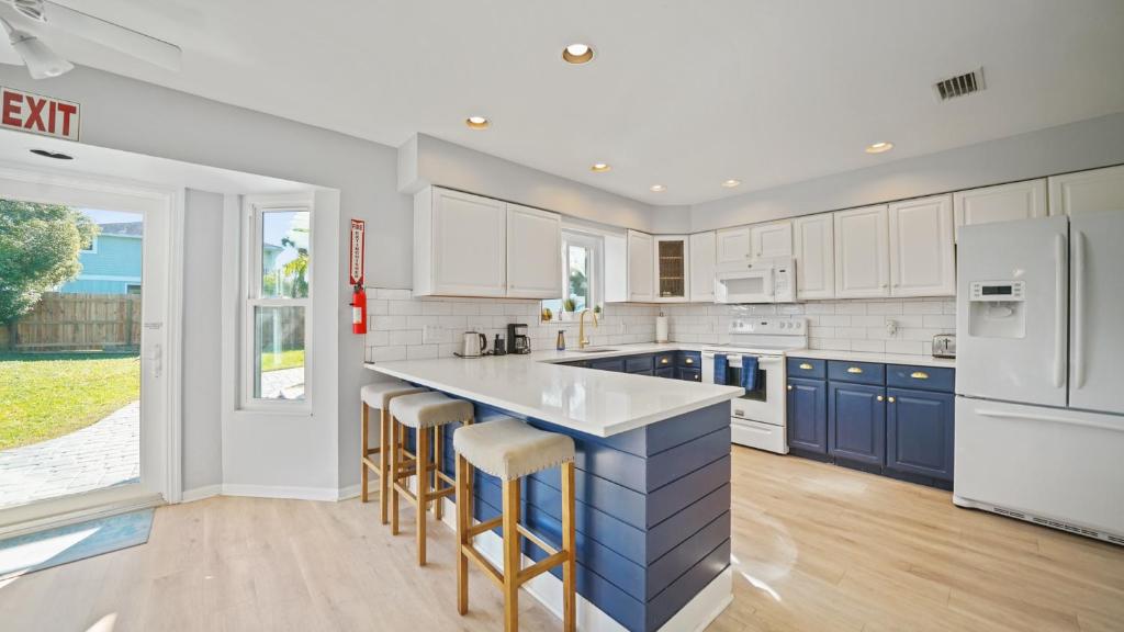 a kitchen with white appliances and blue cabinets at Jacksonville Beach Home - Walk to Beach, Bars & Restaurants - Pet Friendly in Jacksonville Beach