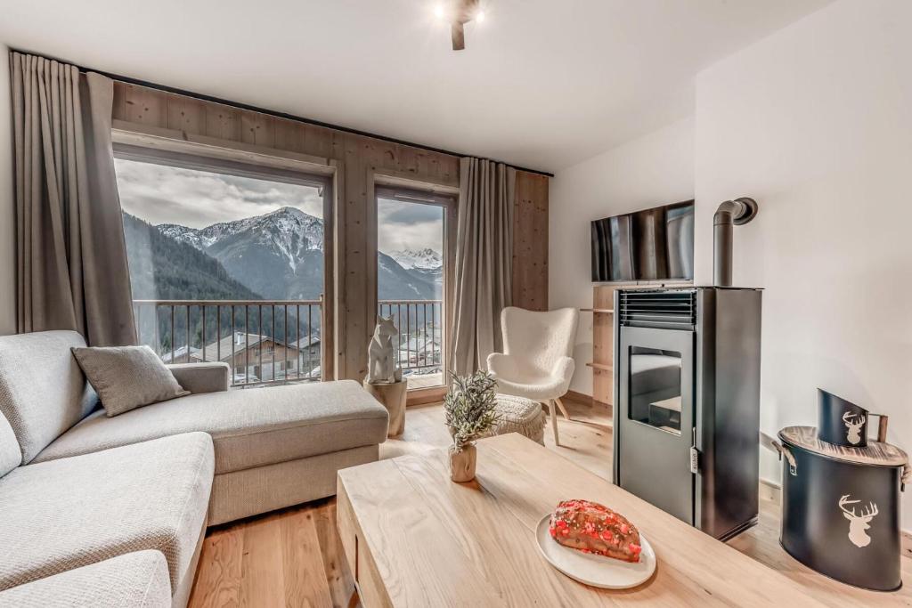 un salon avec un canapé et une grande fenêtre dans l'établissement Résidence Le Grand Bouquetin - 3 Pièces pour 6 Personnes MAE-9984, à Champagny-en-Vanoise