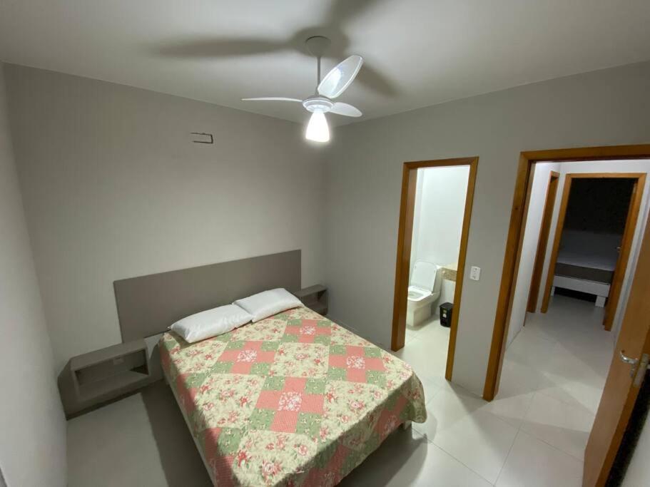 a bedroom with a bed and a ceiling fan at Ótimo Ap a 50m da areia Churrasq 2Q 2banheiros in Torres