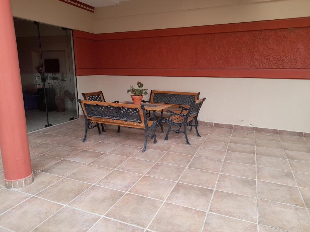 una sala da pranzo con tavolo e sedie su un pavimento piastrellato di Cómo en hogar a Tarija