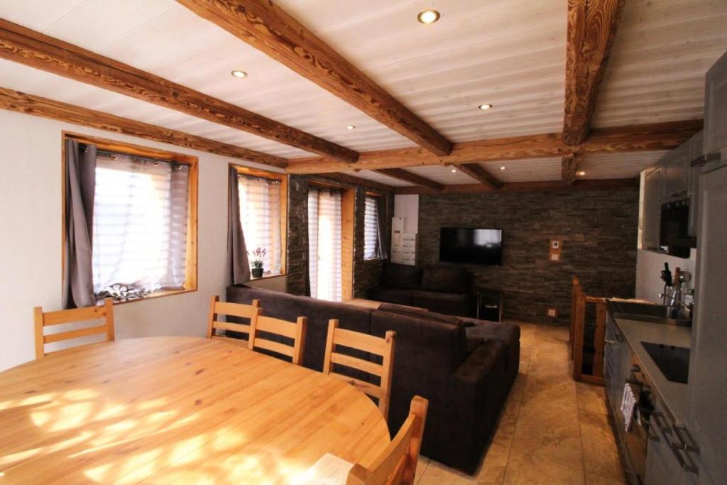 a living room with a wooden table and a couch at Chalet Des Domaines De La Vanoise - Pièces 134 in Peisey-Nancroix