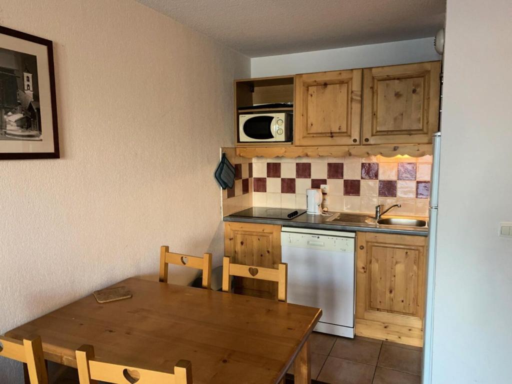 une cuisine avec une table, un évier et une cuisinière dans l'établissement Résidence Cristallines - 2 pièces 4 personnes MAE-4444, à Orcières