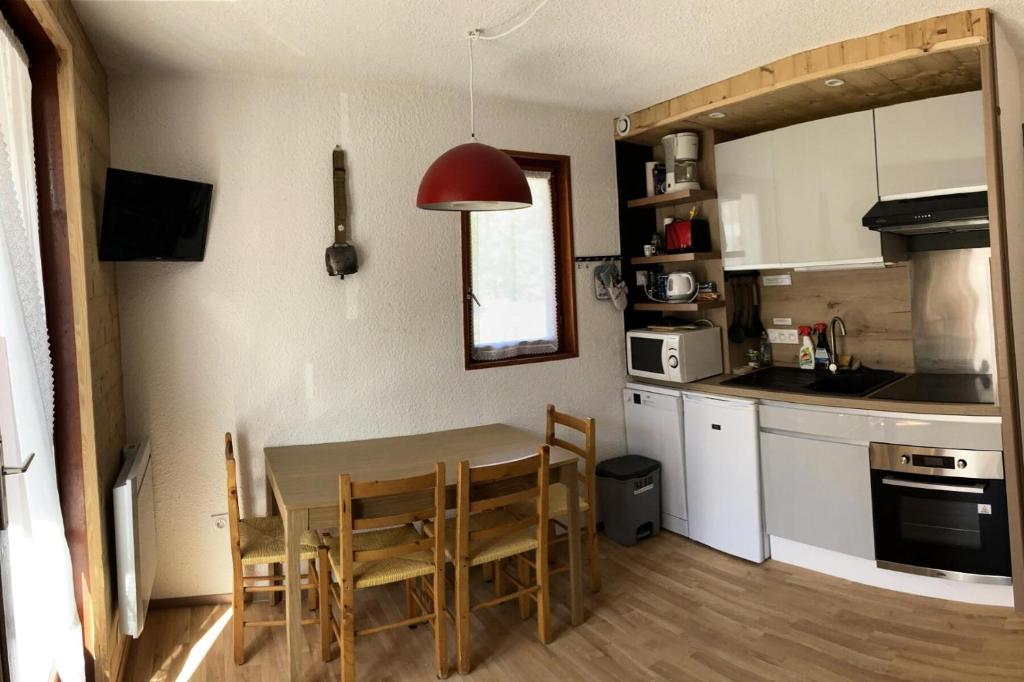 a kitchen with a table and chairs in a room at Résidence Betelgeuse - 2 Pièces pour 4 Personnes 414 in Valloire