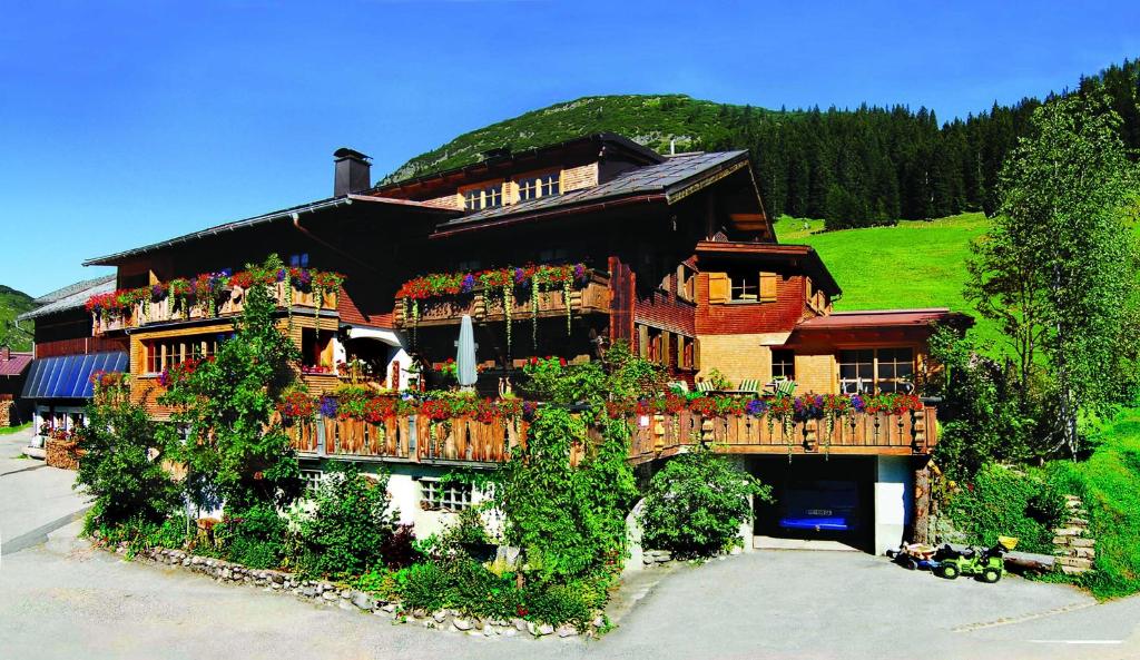 a large house with flowers on the balcony at Biobauernhof Gehrnerhof am Arlberg in Warth am Arlberg