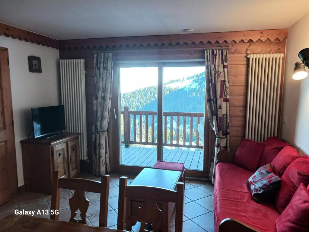 salon z czerwoną kanapą i balkonem w obiekcie Résidence Roselend - Charmant appartement de 3 pièces situé dans une résidence au village du Chantel, proche des pistes et avec piscine. MAE-2474 w mieście Arc 1800