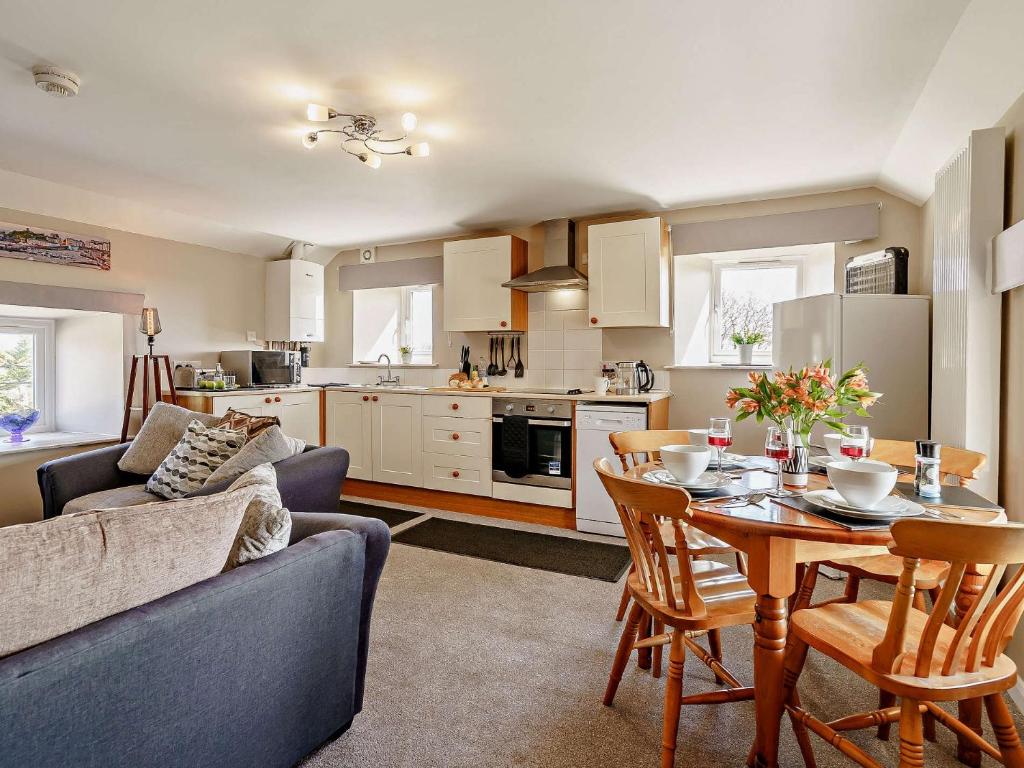uma cozinha e sala de estar com uma mesa e um sofá em 3 Bed in Cosheston 90732 em Cosheston