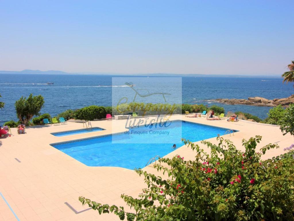 una piscina con vista sull'oceano sullo sfondo di Apartamento Roses, 2 dormitorios, 4 personas - ES-228-152 a Roses