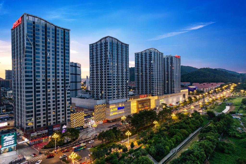 un perfil urbano con edificios altos y luces de la calle en East Maple International Apartment - Guangzhou Luogang Wanda Plaza Suyuan Metro Station, en Guangzhou