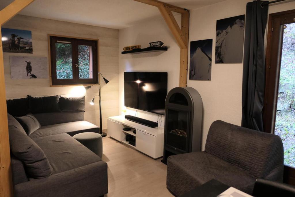 un salon avec un canapé et une télévision dans l'établissement Les Chalet Du Soleil - Chalets du Soleil 9 MAE-6344, à Saint-Gervais-les-Bains