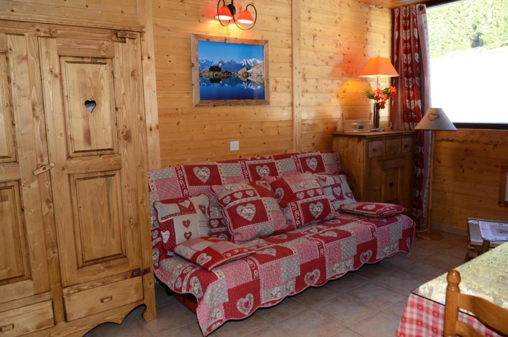 een slaapkamer met een bed in een blokhut bij Résidence Andromede - Studio pour 4 Personnes 274 in Magland