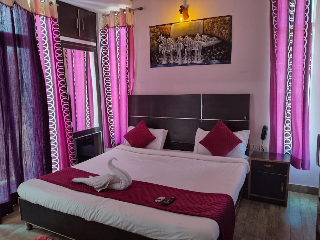 a bedroom with a large bed with pink curtains at Hotel golden gate dx in New Delhi