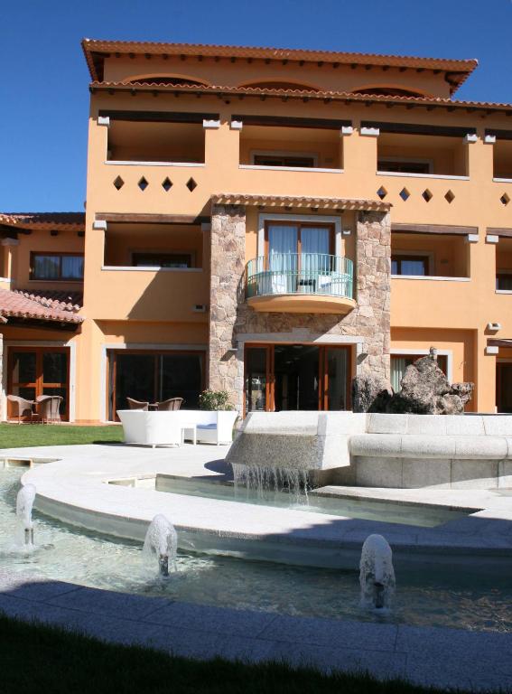 a building with a fountain in front of it at Hotel Marana in Golfo Aranci