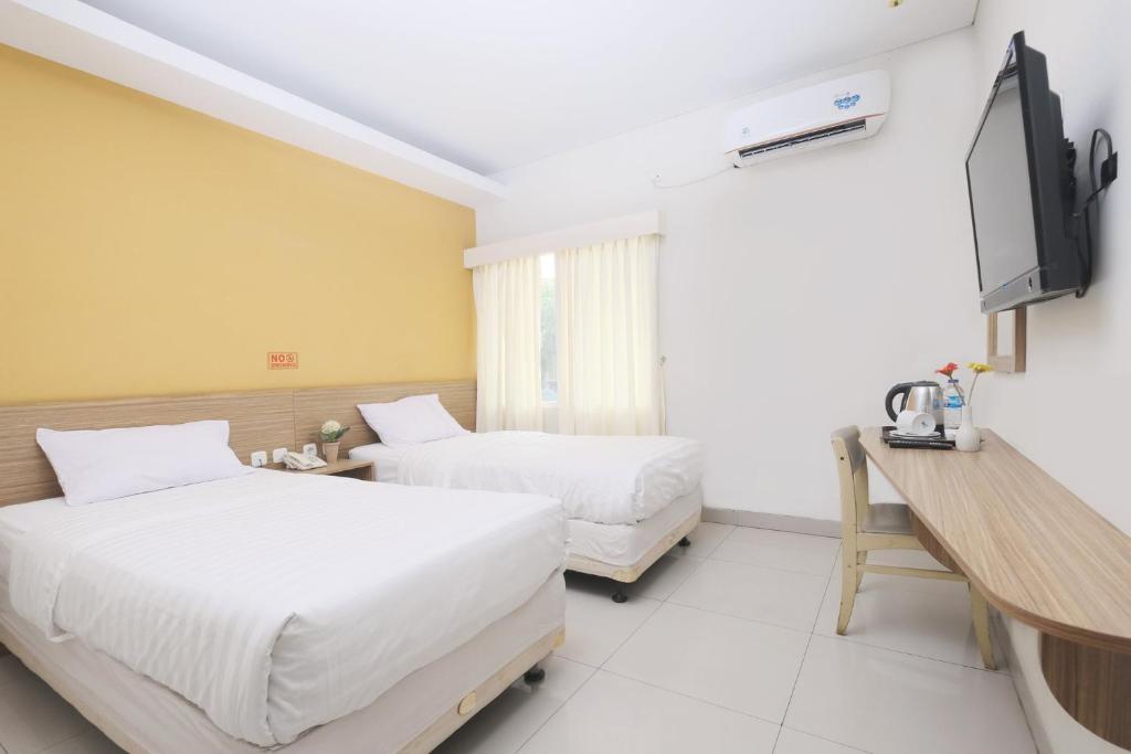 Postel nebo postele na pokoji v ubytování Cengkareng Transit Hotel