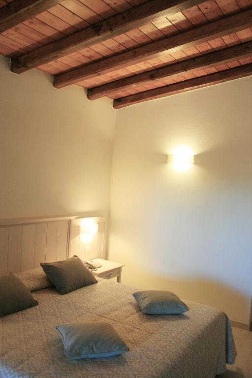 a bedroom with two beds and a table on a wall at Hotel Marana in Golfo Aranci