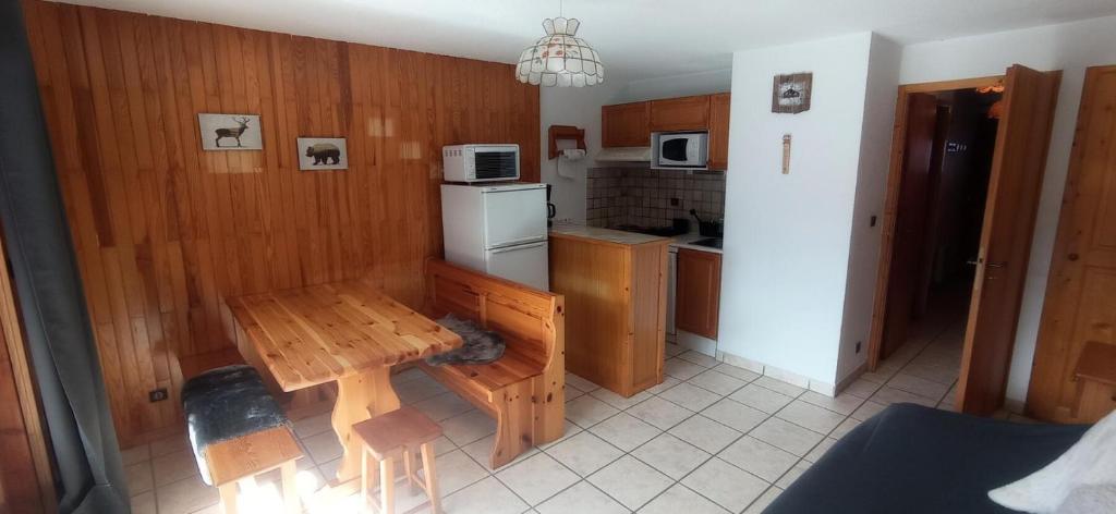 une cuisine avec une table en bois et une petite table dans l'établissement Résidence Le Chardonnet - Appartement à 200 m des pistes avec vue MAE-9544, à Champagny-en-Vanoise