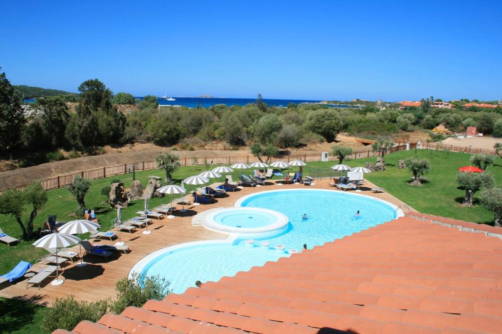 a view of a swimming pool with umbrellas and chairs at Hotel Marana in Golfo Aranci