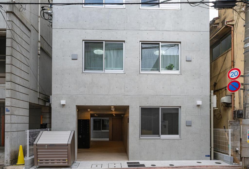 um grande edifício de cimento com um corredor em frente em REPURE OMORI RESIDENCE em Tóquio