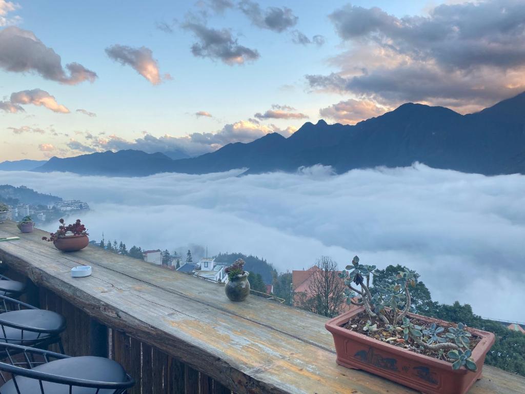 un balcón con vistas a las montañas con nubes en GO SAPA HOSTEL, en Sa Pa