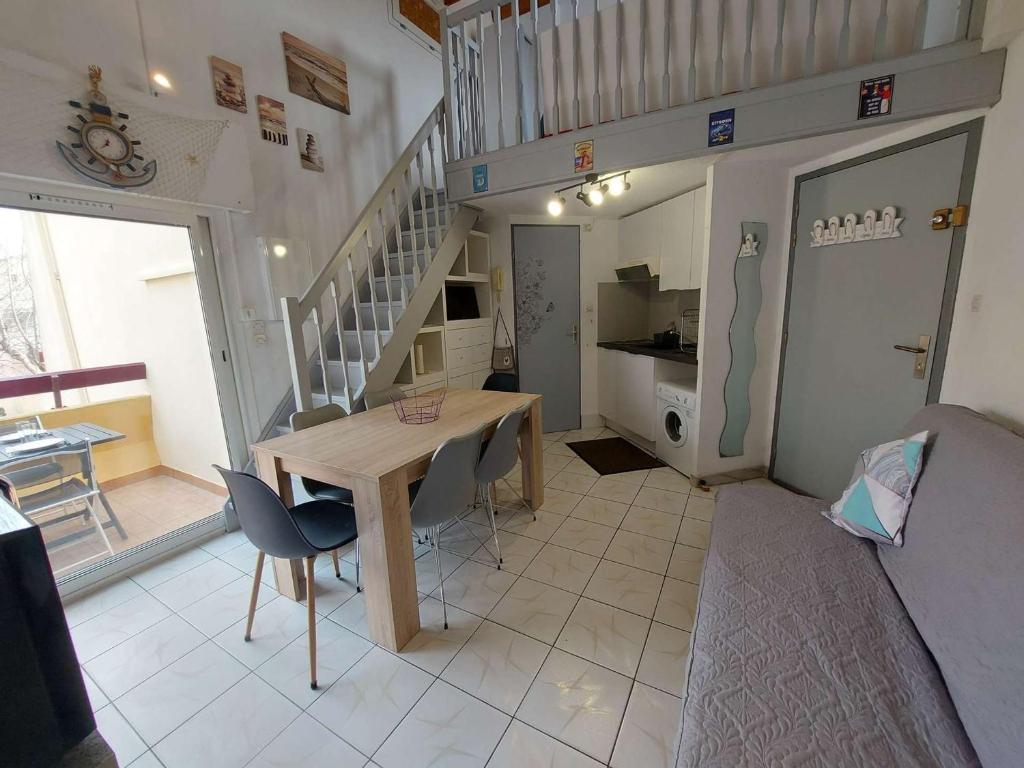 une chambre avec une table, des chaises et un escalier dans l'établissement Appartement Marseillan-Plage, 2 pièces, 6 personnes - FR-1-326-798, à Marseillan