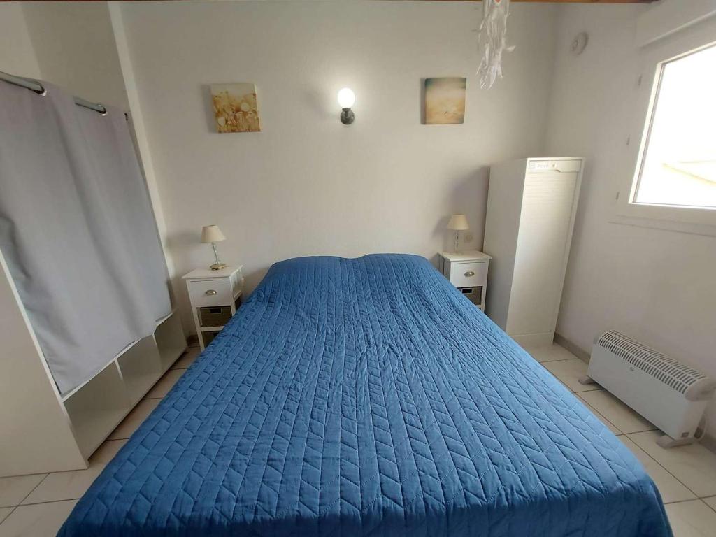 a blue bed in a white room with a window at Appartement Marseillan-Plage, 2 pièces, 6 personnes - FR-1-326-798 in Marseillan