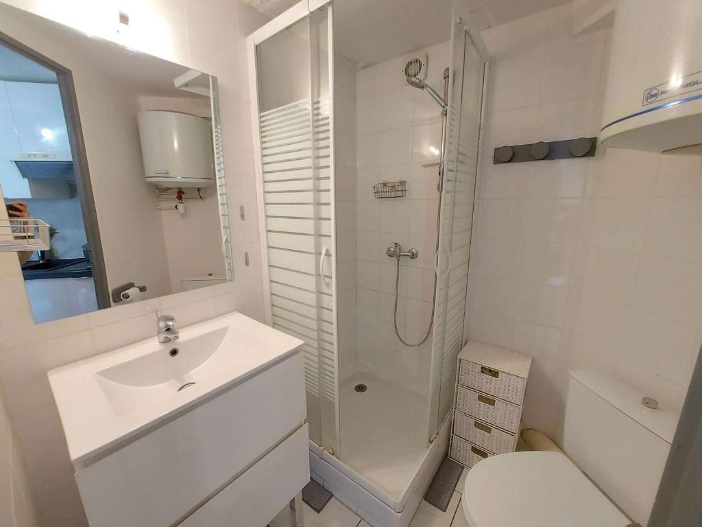 a white bathroom with a sink and a shower at Appartement Marseillan-Plage, 2 pièces, 6 personnes - FR-1-326-798 in Marseillan