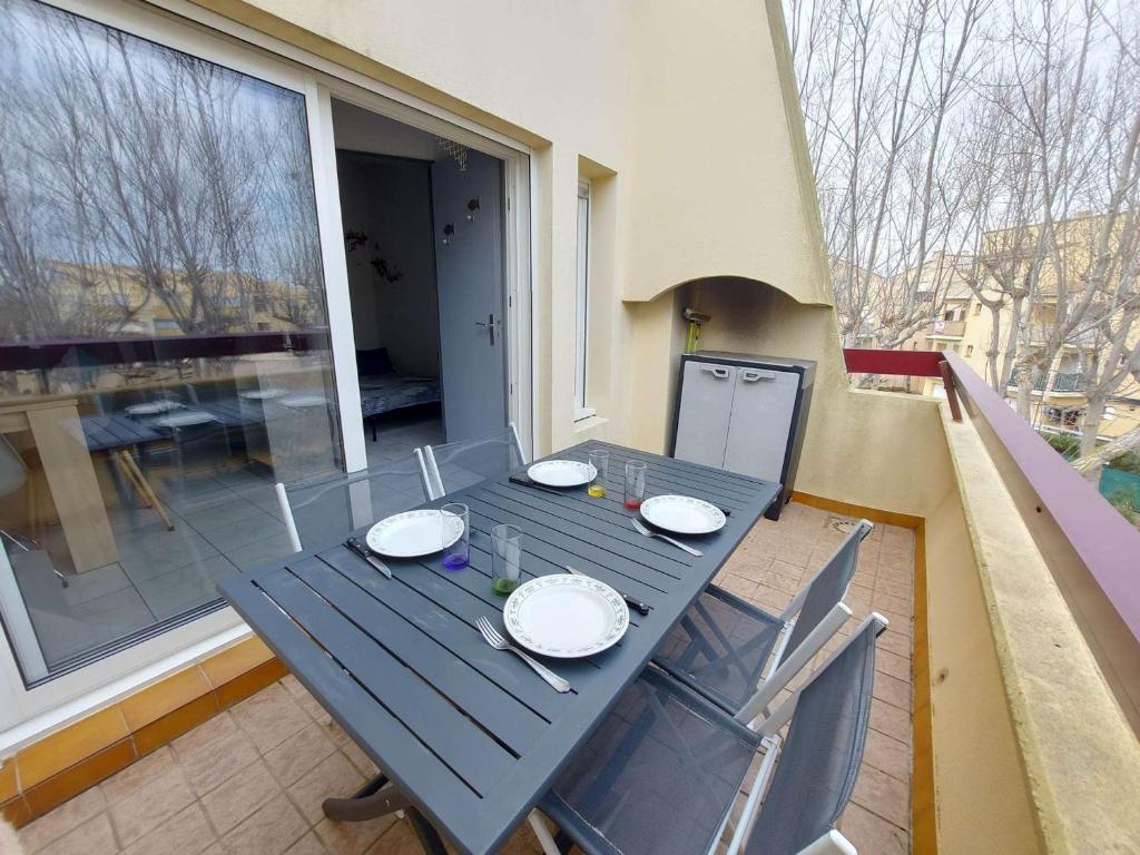 a black table and chairs on a balcony at Appartement Marseillan-Plage, 2 pièces, 6 personnes - FR-1-326-798 in Marseillan