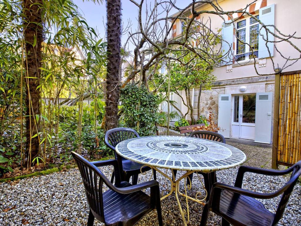 d'une terrasse avec une table et quatre chaises. dans l'établissement Charmant T2 en rez-de-jardin à 800m du centre-ville d'Arcachon, terrasse et parking inclus - FR-1-433-112, à Arcachon