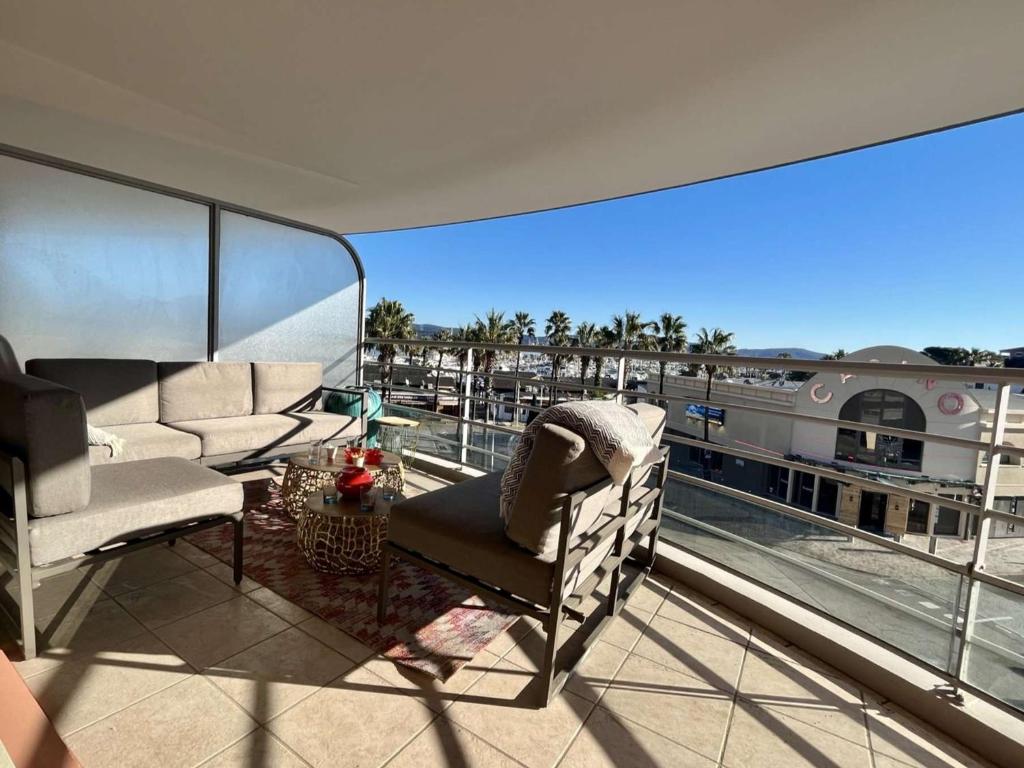 d'un balcon avec des chaises et une vue sur un bâtiment. dans l'établissement Cavalaire: Spacieux T4, 2 Terrasses, Clim, Parking, Animaux Acceptés - FR-1-226B-180, à Cavalaire-sur-Mer