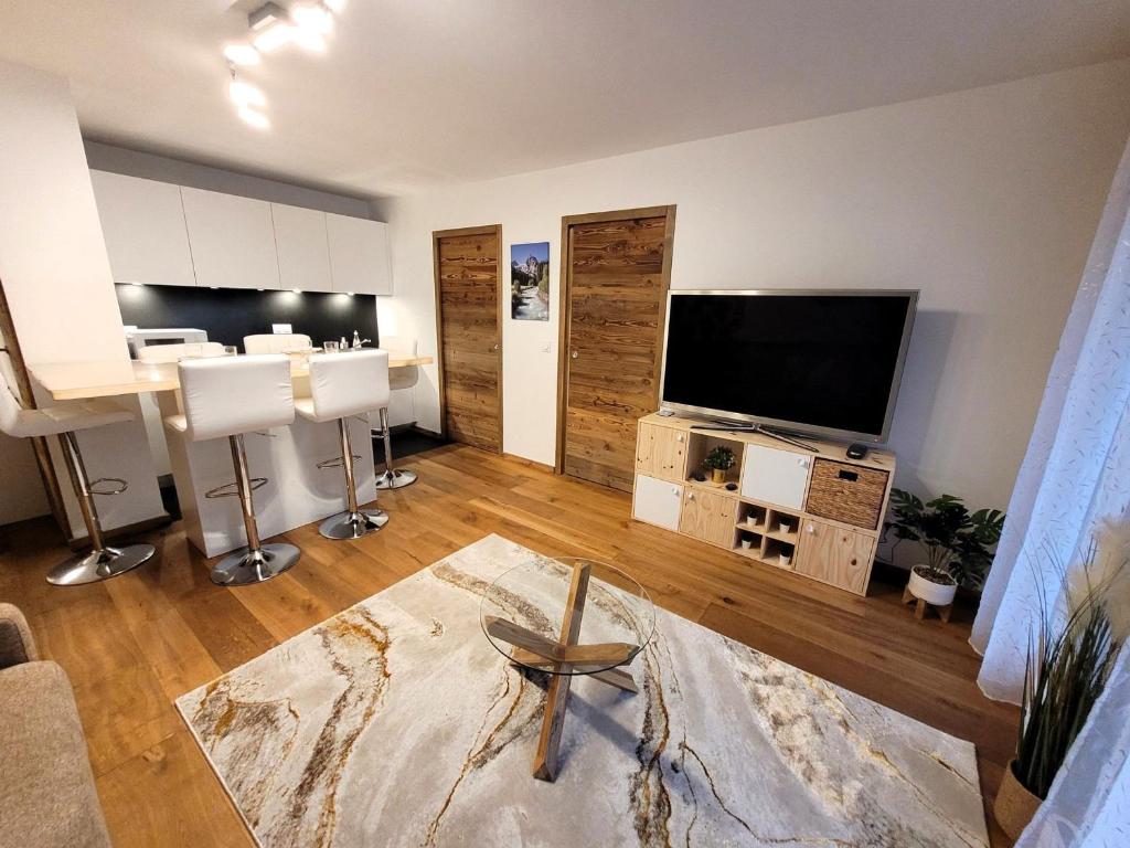 un salon avec une télévision à écran plat et une chaise dans l'établissement Appartement neuf 32 m² au centre des Gets, pour 4 personnes, proche des commerces et pistes de ski - FR-1-598-160, aux Gets
