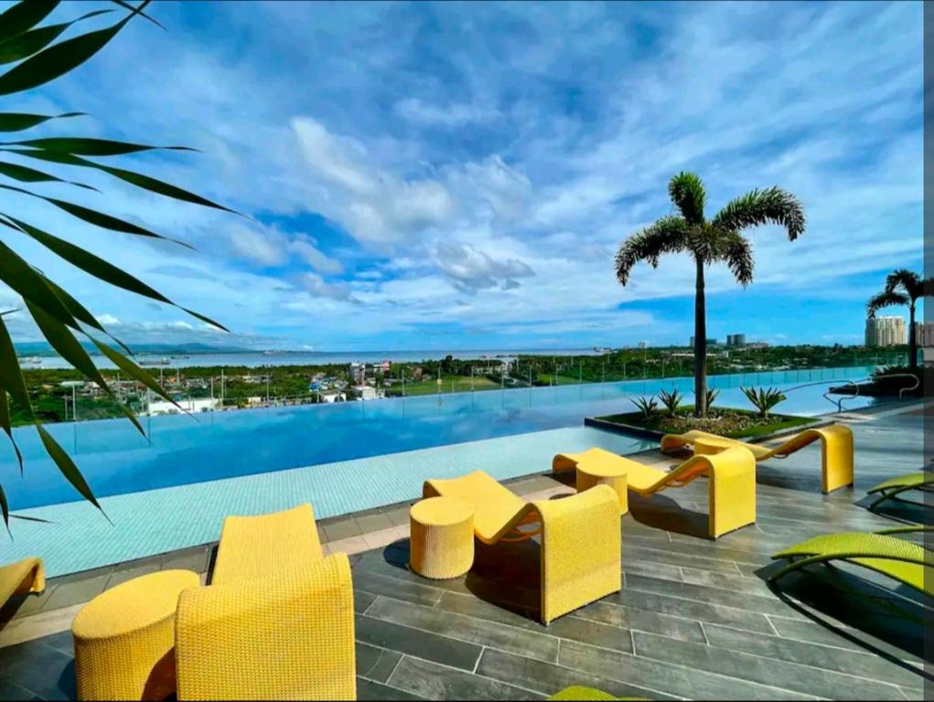 - une piscine avec des chaises jaunes dans l'établissement Condo in Mactan Newtown with pool and beach access, à Mactan