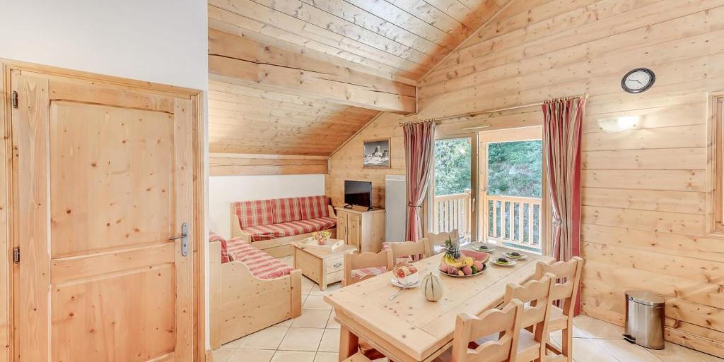 Cette chambre en bois comprend une table et un canapé. dans l'établissement Résidence Les Alpages - 3 Pièces pour 8 Personnes MAE-4274, à Champagny-en-Vanoise