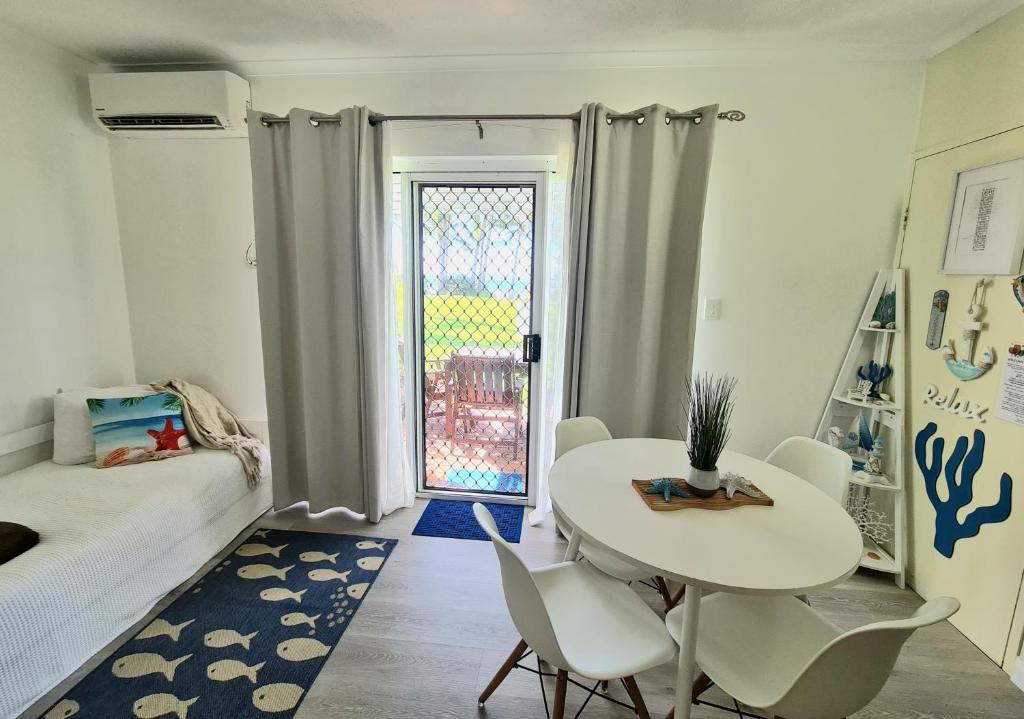 um quarto com uma mesa e cadeiras e uma cama em Dolphin Heads - Resort Unit - Absolute Beachfront! - Whitsunday Getaway! em Mackay