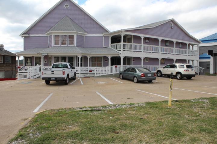 una casa púrpura con coches aparcados en un estacionamiento en 76 Family Inn, en Branson