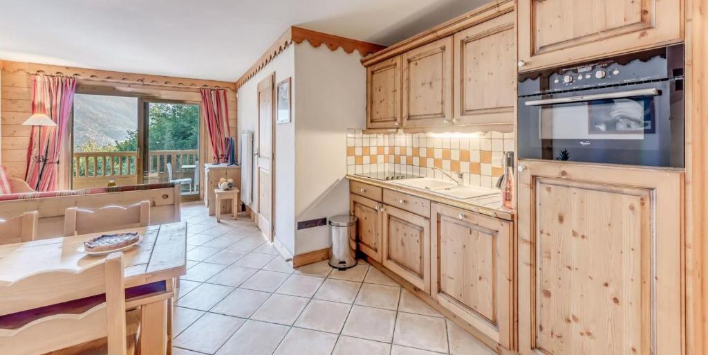 une cuisine avec des placards en bois et une grande fenêtre dans l'établissement Résidence Les Alpages - 4 Pièces pour 8 Personnes MAE-3834, à Champagny-en-Vanoise
