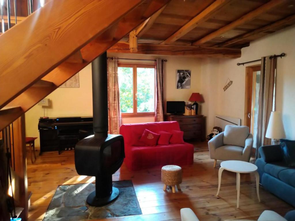 a living room with a red couch and a wood stove at Résidence La Grange Des Flocons - Chalets pour 12 Personnes 894 in Valloire