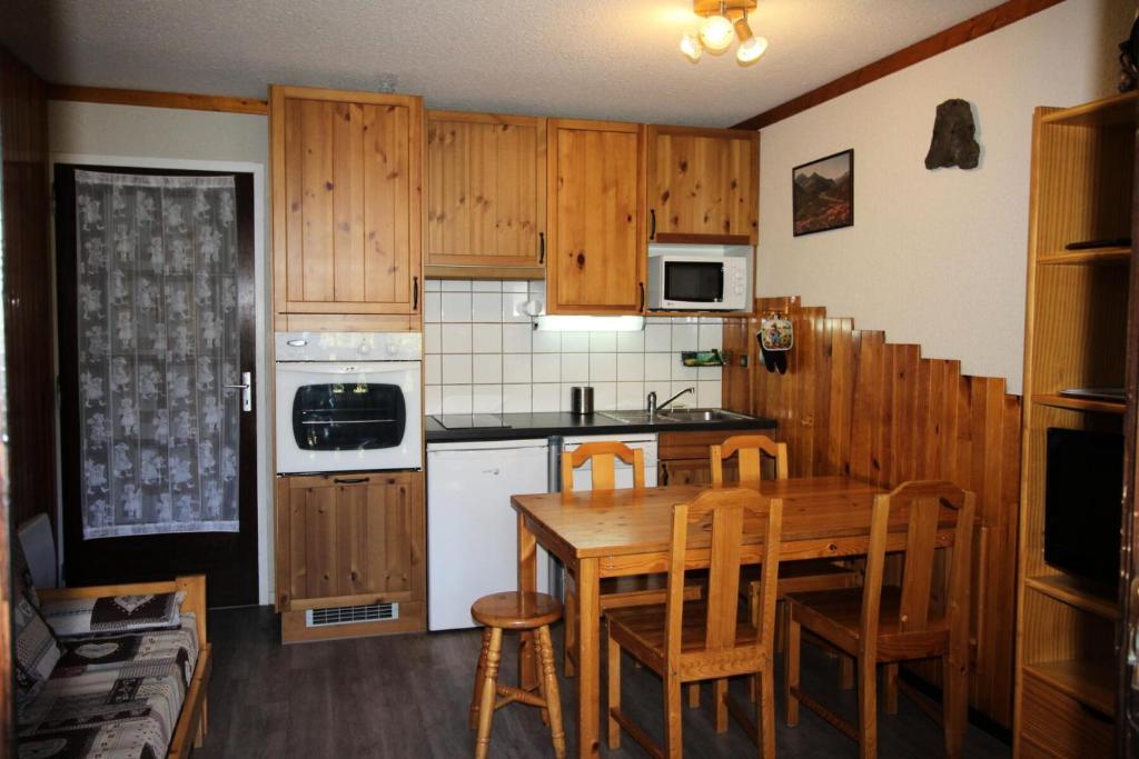 una cocina con armarios de madera y una mesa y sillas de madera. en Résidence Les Epervieres - Appartement dans chalet au calme, à l'orée de la forêt MAE-4394, en Villarodin-Bourget